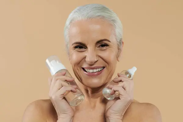 A mature woman joyfully celebrates beauty products together. — Stock Photo