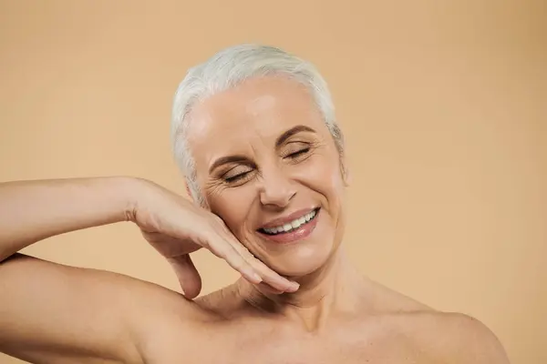 A happy woman with short hair posing on pastel backdrop. — Stock Photo