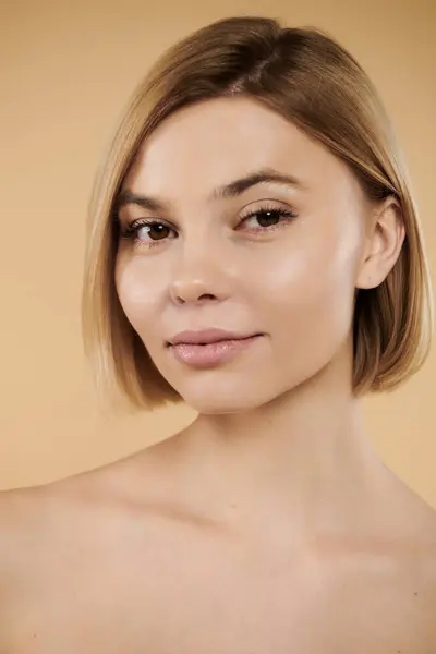 Appealing woman looking at camera on pastel backdrop. — Stock Photo