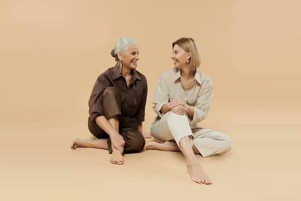 Two generations share smiles and laughter in a cozy, warm toned space. — Stock Photo