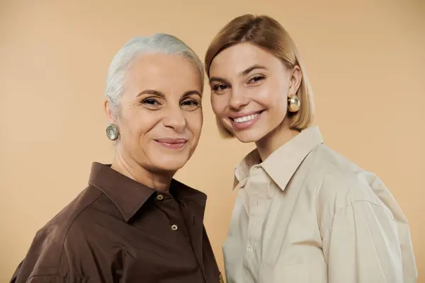 Una madre gioiosa e una figlia condividono un sorriso amorevole mentre posano insieme. — Foto stock