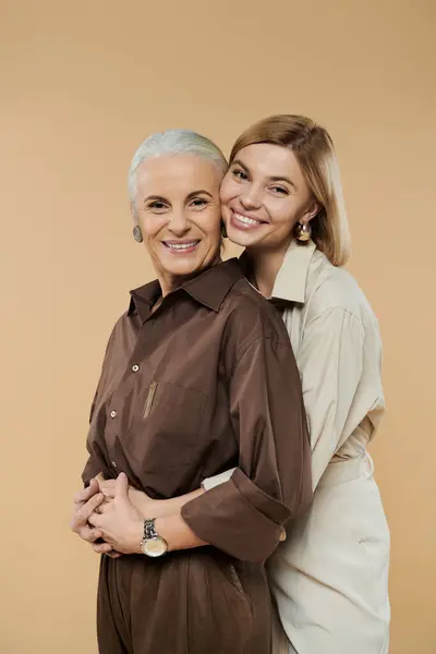A mature woman and her daughter share a joyful embrace, smiling warmly. — Stock Photo