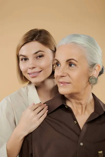 A mature woman enjoys a tender moment with her adult daughter. — Stock Photo