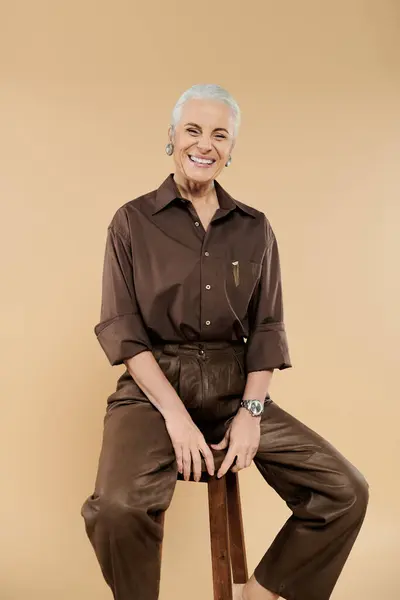 A joyful moment of cheerful woman sitting on tall chair. — Stock Photo