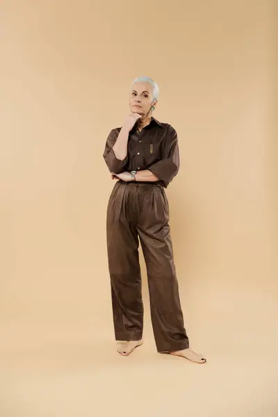 A mature woman posing and looking at camera, elegant attire. — Stock Photo