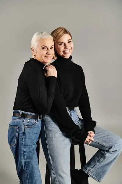 Una donna matura e sua figlia condividono un momento gioioso in abiti eleganti. — Stock Photo