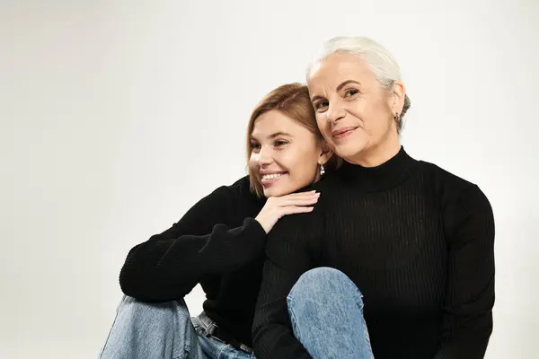 Eine reife Frau und ihre Tochter teilen eine warme, verspielte Umarmung, die Freude ausstrahlt. — Stockfoto