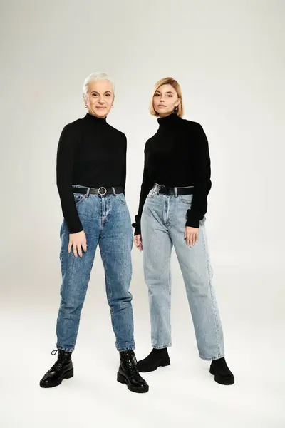 A mature woman stands confidently with her adult daughter, both in chic outfits. — Stock Photo