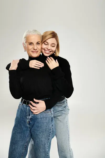 A mature woman joyfully hugs her adult daughter in a warm embrace. — Stock Photo