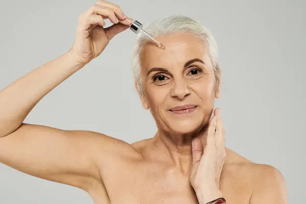 A woman applies skincare and looking at camera. — Stock Photo