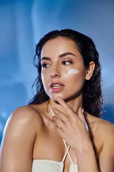 Una bella giovane donna posa con la crema per la pelle sul viso. — Foto stock