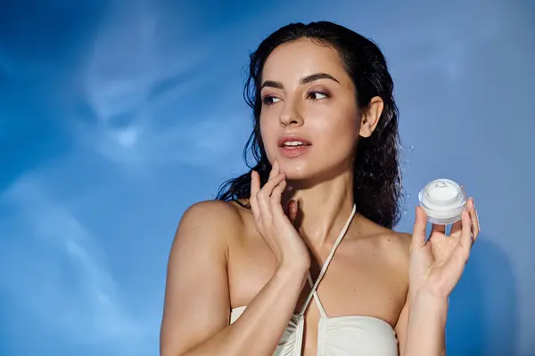 A woman applies cream, radiating confidence and beauty. — Stock Photo