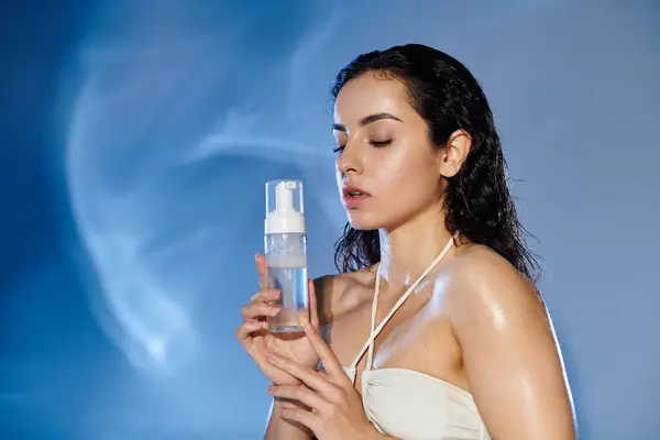 Woman enjoys a refreshing skincare moment with a bright backdrop. — Stock Photo
