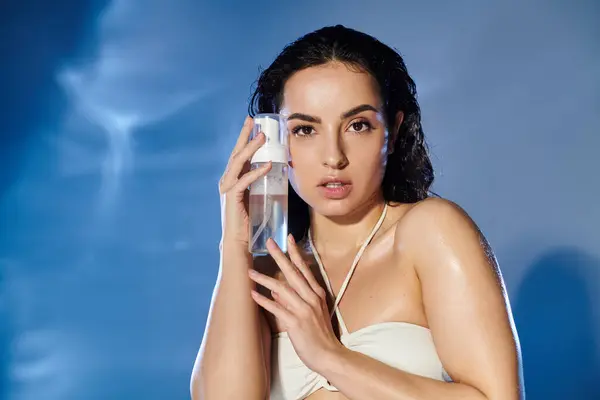 Woman poses with a skincare product, radiating confidence and beauty. — Stock Photo
