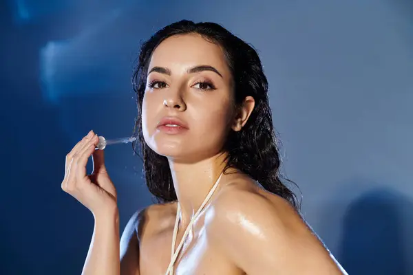 A young woman applies serum while showcasing her radiant skin. — Stock Photo