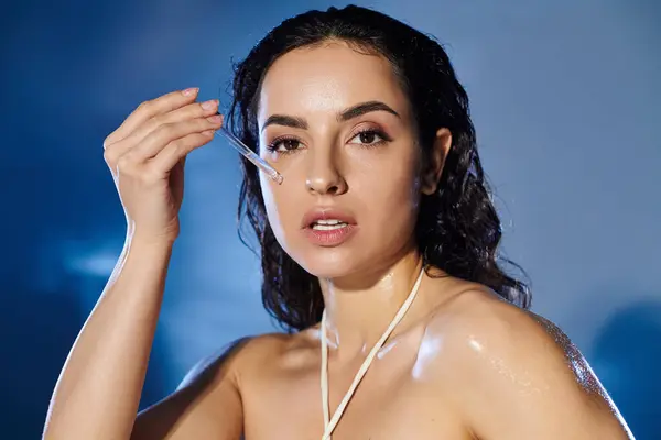 Jovem mulher aplica soro enquanto posando com um fundo vibrante. — Fotografia de Stock