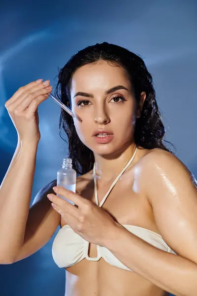 Beautiful young woman showcases her skincare routine with a glowing serum. — Stock Photo