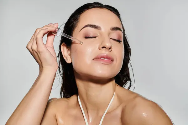 A beautiful woman enjoys her skincare routine with a serum application. — Stock Photo