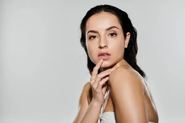 Una giovane bella donna dimostra la sua routine di cura della pelle elegantemente. — Foto stock