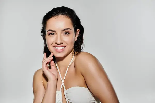 A young woman smiles while showcasing her skincare routine with a vibrant background. — Stock Photo