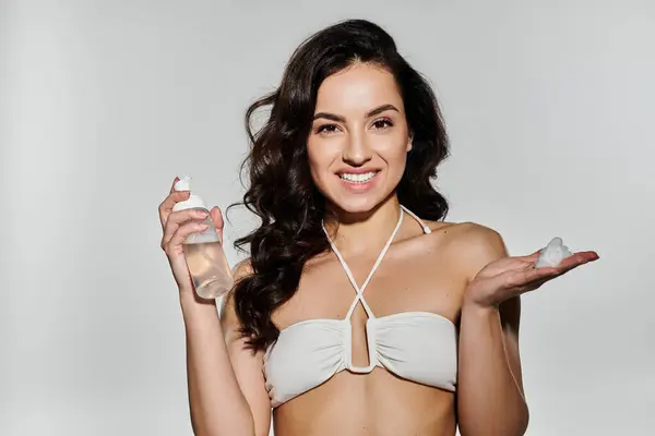 Uma mulher sorridente demonstra produtos de cuidados com a pele com uma pose lúdica. — Stock Photo