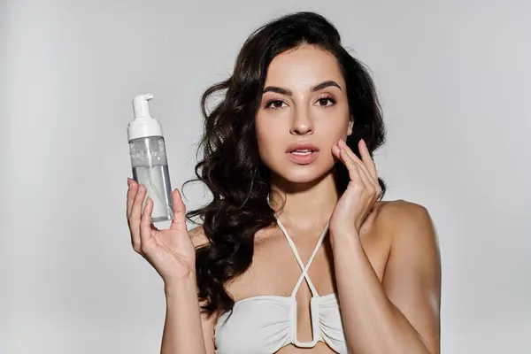 A beautiful woman demonstrates her skincare regimen with a radiant smile. — Stock Photo