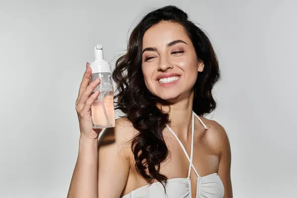 Beautiful woman enjoying her skincare routine in a colorful setting. — Stock Photo