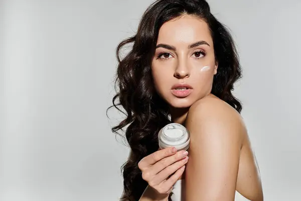 Una bella giovane donna dimostra la sua routine di cura della pelle con eleganza. — Foto stock