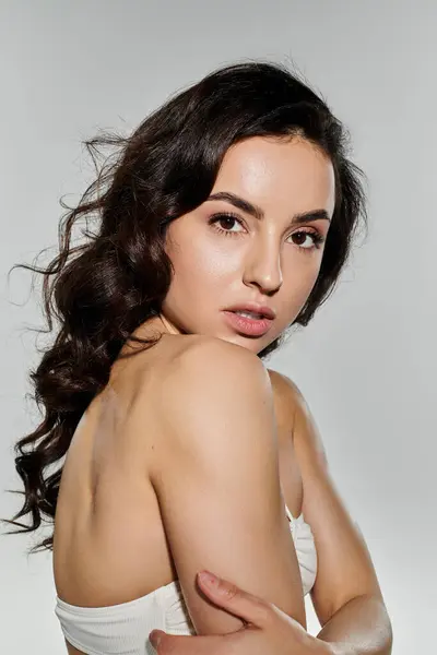 Attraente donna bruna con i capelli lunghi in costume da bagno in posa attiva. — Foto stock