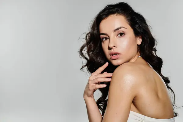 Mulher morena envolvente com cabelos longos em maiô posando ativamente. — Fotografia de Stock