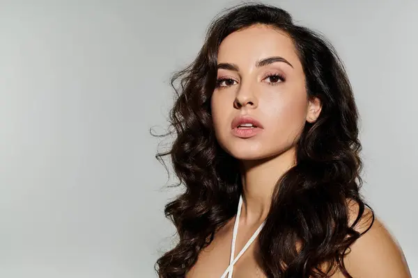 Young woman with long hair posing on white backdrop. — Stock Photo