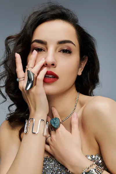 Beautiful woman elegantly poses, highlighting her radiant jewelry. — Stock Photo