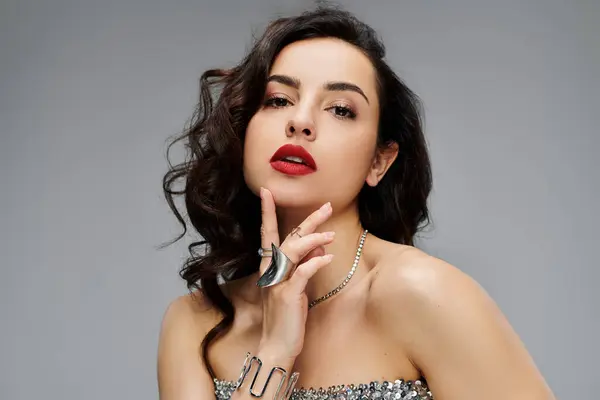 Une belle femme pose en toute confiance, mettant en valeur ses bijoux élégants et son fond vibrant. — Photo de stock