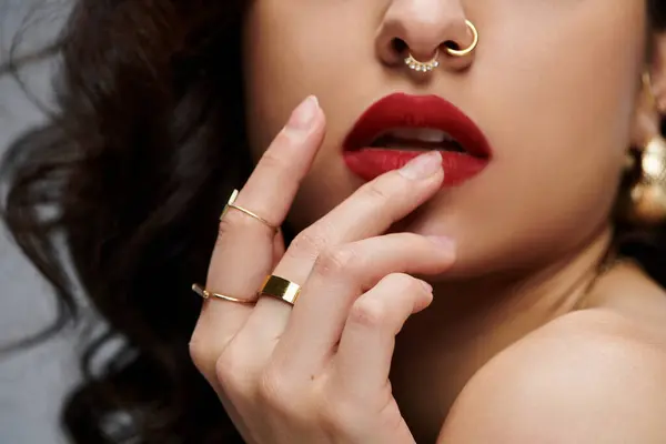 A beautiful young woman poses confidently, adorned in shimmering jewelry. — Stock Photo