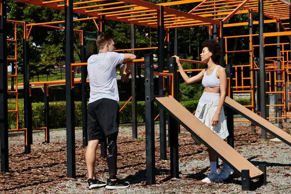Dois amigos colaboram em um treino ao ar livre, exemplificando resiliência e apoio em um ambiente vibrante, homem com perna protética — Fotografia de Stock