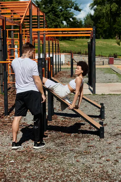 A young woman and a tattooed man engage in a workout, promoting friendship and empowerment in nature. — Stock Photo