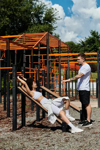 Two friends engage in an energetic workout outdoors, celebrating strength and friendship, man with prosthetic leg looking at african american woman — Stock Photo