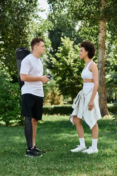 Two friends, a young woman and a tattooed man, engage in an outdoor workout, embracing fitness and inclusion. — Stock Photo
