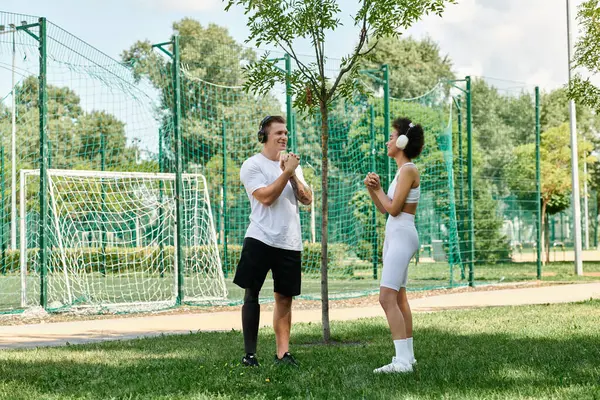 A young woman cheers on her friend with a prosthetic leg as they workout in a vibrant park. — Stock Photo