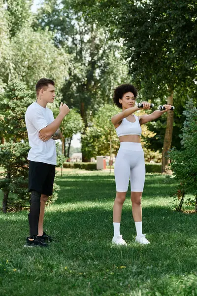 Two friends engage in an outdoor workout, promoting fitness and inclusivity in a sunny park. — Stock Photo