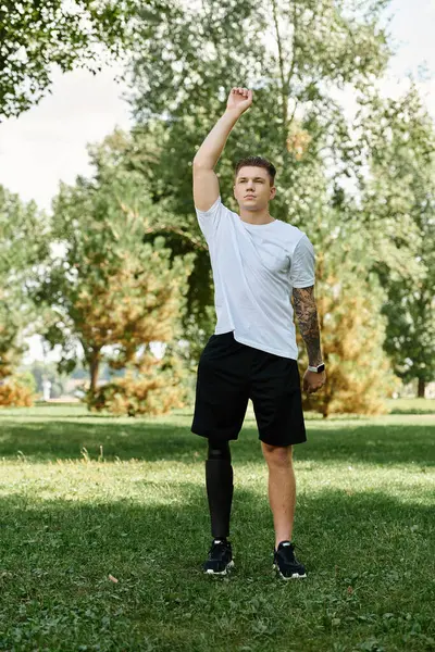 Un joven con una pierna protésica se dedica a un entrenamiento al aire libre, celebrando la fuerza. - foto de stock