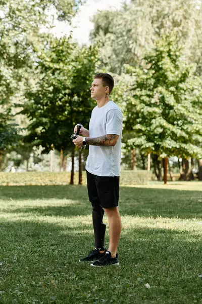 Man with prosthetic leg enjoying an outdoor workout, celebrating diversity and strength in a lush green park. — Stock Photo
