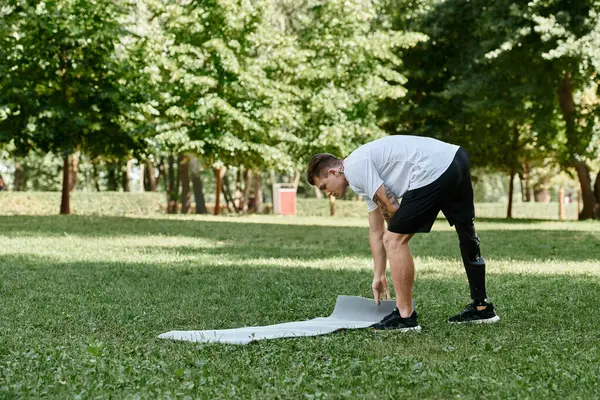 Man with disability in a lush park, embodying strength and determination through outdoor workout. — Stock Photo