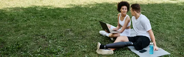 Dois amigos usando laptop na grama, mostrando força, resiliência e amizade. — Fotografia de Stock