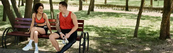 Two friends share a joyful moment while resting together in a sunny park setting. — Stock Photo
