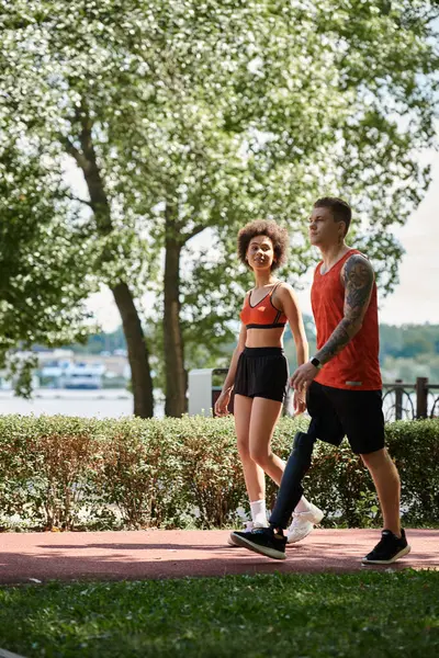 Two friends engage in an energizing workout by the waterfront, celebrating diversity and fitness. — Stock Photo
