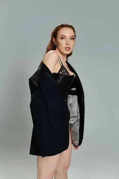 A striking red haired woman showcases contemporary fashion with confidence. — Stock Photo