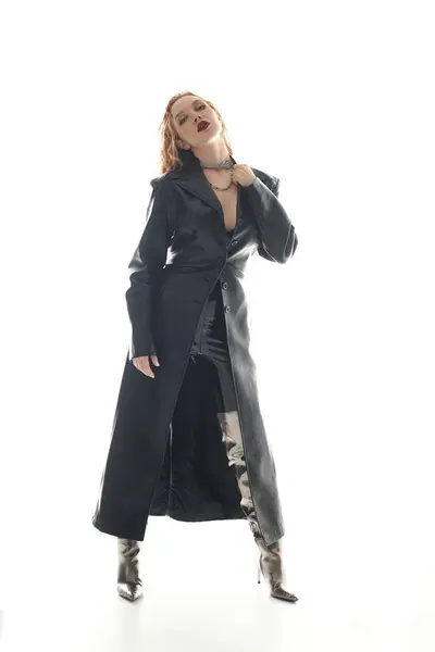 A confident woman in a sleek outfit poses dramatically, exuding elegance and style. — Stock Photo