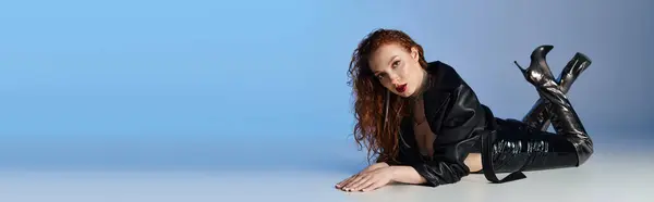 Una donna dai capelli rossi elegante colpisce una posa accattivante su una superficie liscia. — Stock Photo