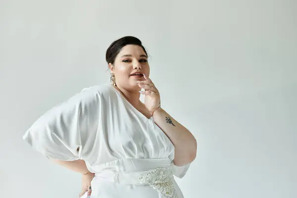 Uma noiva deslumbrante plus size mostra sua elegância com um vestido de noiva branco e brincos espumantes. — Fotografia de Stock